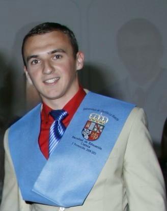 Andrés în costum și cu eșarfa de absolvire a universității
